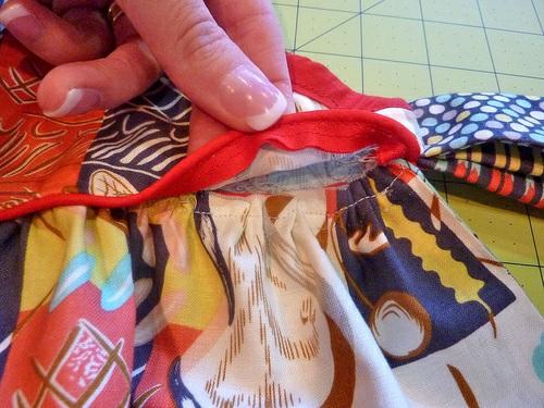 Flip the apron to side B and fold up the bottom raw edge of side B of the bib so the piping itself becomes the bottom edge of