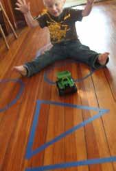 Sit on the floor on opposite sides of the shapes. Roll a ball (or toy truck) back and forth to each other.