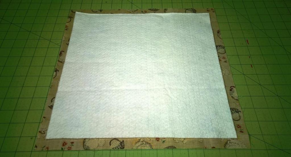 Place 1 square of batting in the center of the wrong side of 1 fabric square.