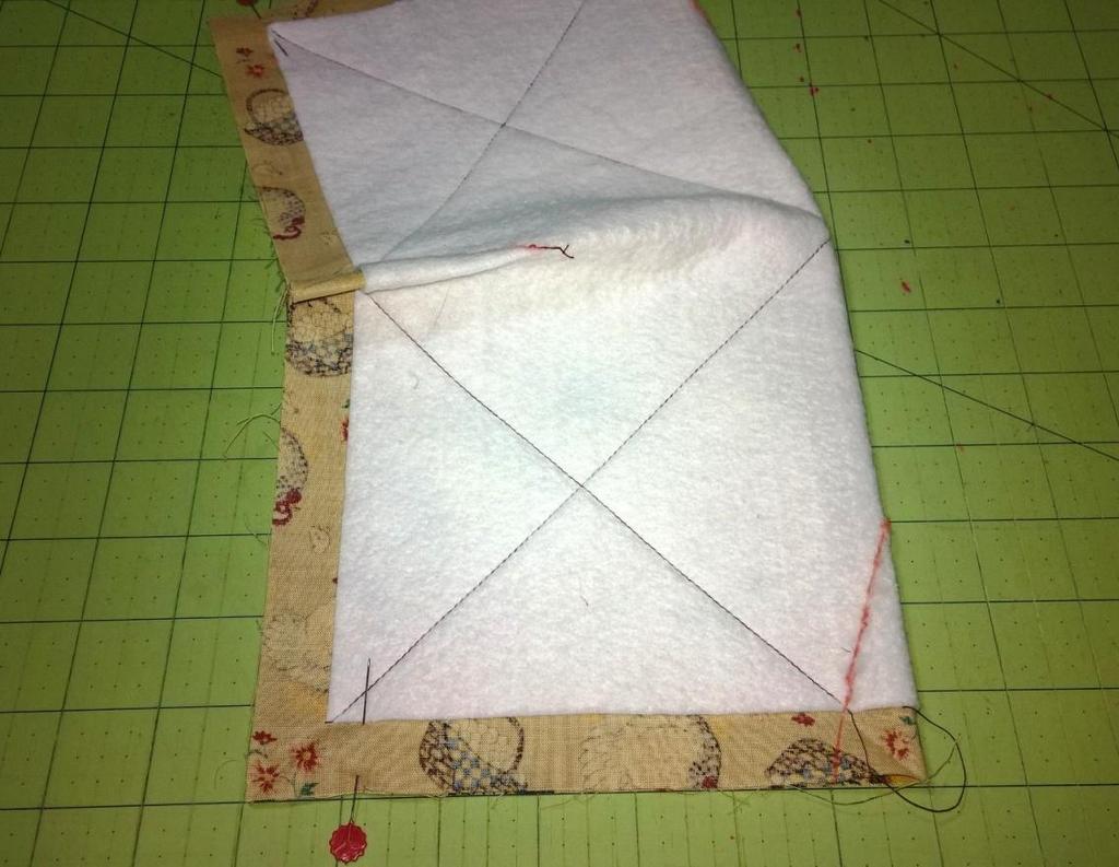 Adding darts to opposite sides Fold your quilted square in half on the opposite sides.