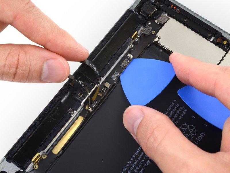 Carefully insert an opening pick under the logic board, between the front-facing camera and the battery.