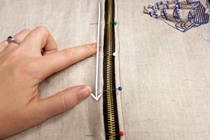Take the piece you just embroidered, and line the top (without the leather) along one side of the zipper.