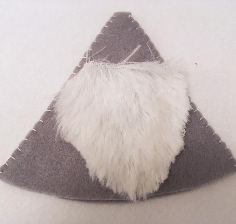 Cut the scrap of white fun fur in to the shape of a beard as shown in the image.