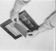 To make a contact print, lay a piece of soft foam rubber on a flat surface, position a sheet of printing paper over it, set the negative(s) in place on top of the paper, and cover the stack with the