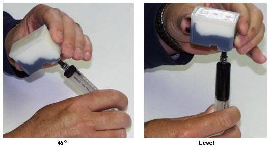 E) While holding the syringe vertical, pointed up, wrap some paper towel around the tip of the Bottom Fill Adapter, and carefully push on the syringe to remove any air trapped in the top of the