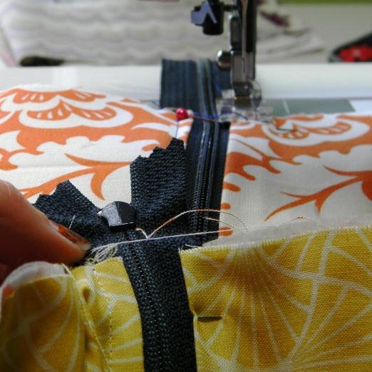 Using the zipper as your guide, top stitch along folded edge as shown in the picture. Repeat with the other side.