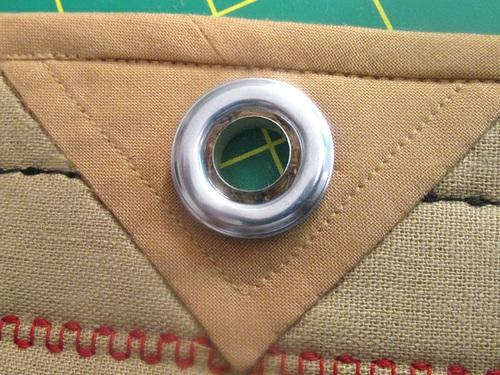 NOTE: After cutting each hole, you can add a drop of seam sealant, such as Fray Check to prevent raveling. Then finish the grommet installation. 2. Find one of the 6 hanger loops. 3.