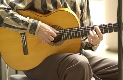 Playing guitar for hours can strain your back if you do not maintain an upright posture. Pick up your guitar and place the back of the guitar against your stomach.